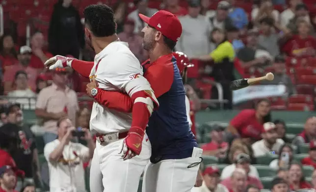 St. Louis Cardinals' Willson Contreras, left, throws his bat while being held back by Cardinals bench coach Daniel Descalso after being ejected during the seventh inning of a baseball game against the Pittsburgh Pirates Monday, Aug. 25, 2025, in St. Louis. (AP Photo/Jeff Roberson)