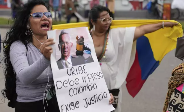 Opponents of former President Alvaro Uribe gather outside the court on the day he was sentenced to 12 years under house arrest for witness tampering and bribery in Bogota, Colombia, Friday, Aug. 1, 2025. (AP Photo/Fernando Vergara)