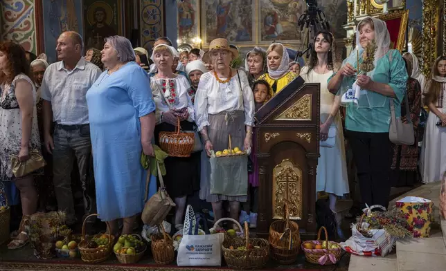 People pray as they mark the Feast of the Transfiguration of the Lord at St. Michael's Golden-Domed Cathedral in Kyiv, Ukraine, Wednesday, Aug. 6, 2025. (AP Photo/Danylo Antoniuk)