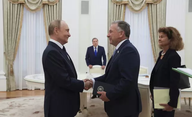 Russian President Vladimir Putin, left, and U.S. President Donald Trump's special envoy Steve Witkoff, right, shake hands during their meeting at the Kremlin in Moscow, Russia, Wednesday, Aug. 6, 2025. (Gavriil Grigorov, Sputnik, Kremlin Pool Photo via AP)