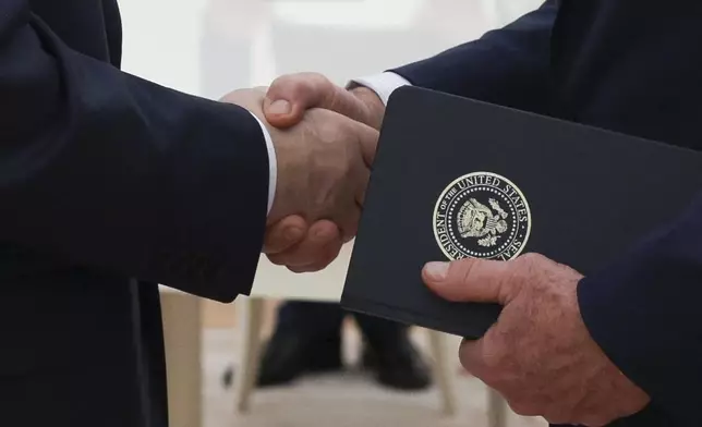 Russian President Vladimir Putin, left, and U.S. President Donald Trump's special envoy Steve Witkoff, right, shake hands during their meeting at the Kremlin in Moscow, Russia, Wednesday, Aug. 6, 2025. (Gavriil Grigorov, Sputnik, Kremlin Pool Photo via AP)
