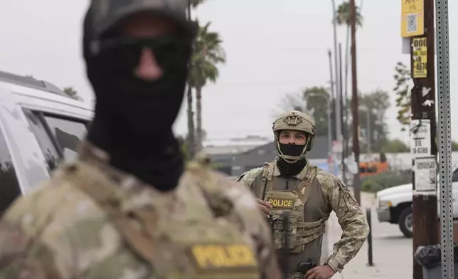 Federal agents stage outside a Home Depot during an operation Friday, Aug. 15, 2025, in Los Angeles. (AP Photo/Gregory Bull)
