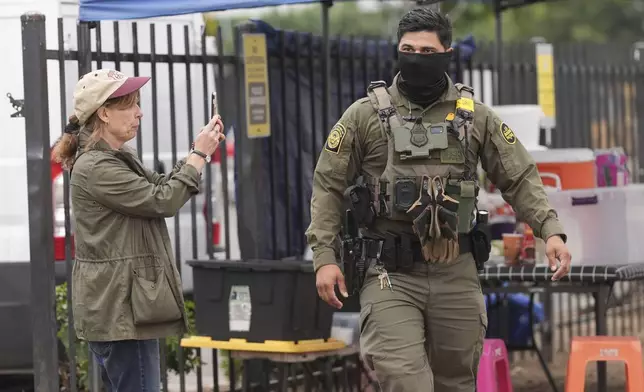 A U.S. Customs and Border Protection agent is filmed during an operation outside a Home Depot Friday, Aug. 15, 2025, in Los Angeles. (AP Photo/Gregory Bull)