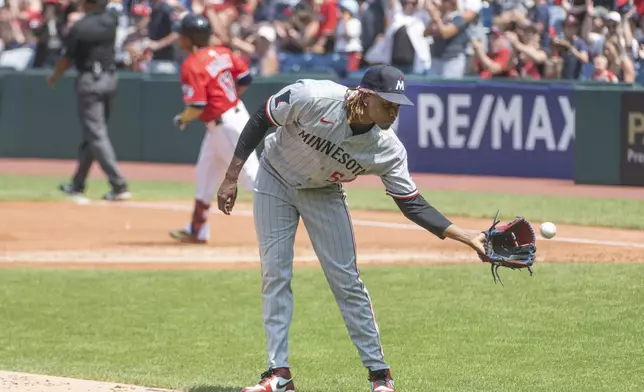 Minnesota Twins relief pitcher Jose Urena, front, reaches for the ball as Cleveland Guardians' Jose Ramirez rounds the bases after hitting a two-run home run during the first inning of a baseball game, Sunday, Aug. 3, 2025, in Cleveland. (AP Photo/Phil Long)