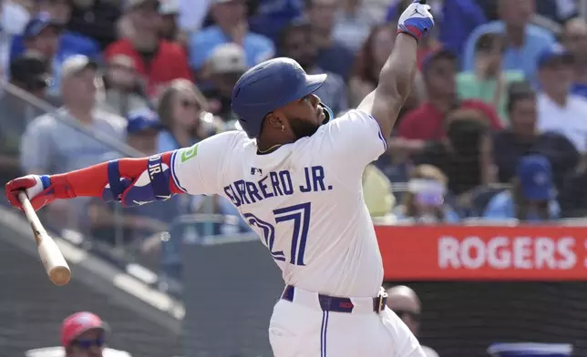 Toronto Blue Jays first base Vladimir Guerrero Jr. (27) hits a sacrifice fly to score teammate George Springer during sixth inning MLB baseball action against Milwaukee Brewers pitcher Quinn Priester in Toronto on Saturday, August 30, 2025. (Frank Gunn/The Canadian Press via AP)
