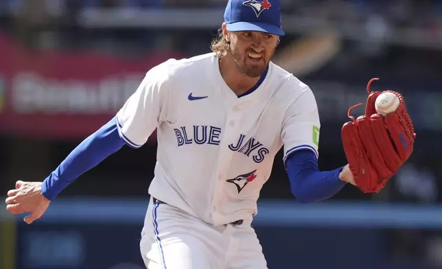 Toronto Blue Jays pitcher Kevin Gausman (34) holds on to the ball as he runs outs Milwaukee Brewers outfielder Sal Frelick at first base during fourth inning MLB baseball action in Toronto on Saturday, August 30, 2025. (Frank Gunn/The Canadian Press via AP)