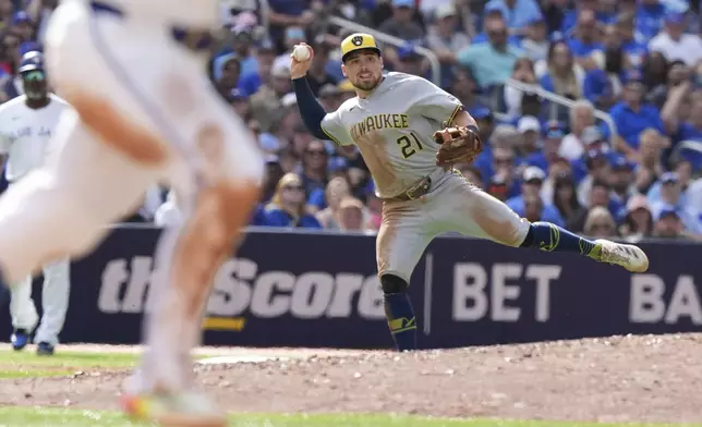 Milwaukee Brewers third baseman Caleb Durbin (21) cannot make a throw in time to put out Toronto Blue Jays' Ty France at first base during the fifth inning of a baseball game in Toronto, Saturday, Aug. 30, 2025. (Frank Gunn/The Canadian Press via AP)