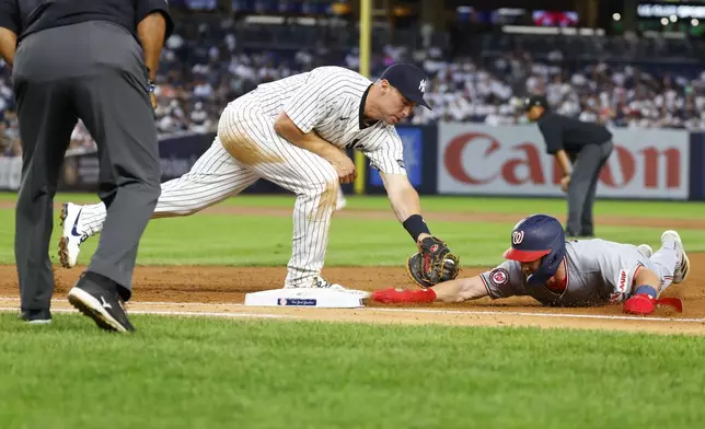 New York Yankees first baseman Paul Goldschmidt, center, picks off Washington Nationals' Jacob Young, right, for an out during the third inning of a baseball game, Monday, Aug. 25, 2025, in New York. (AP Photo/Noah K. Murray)