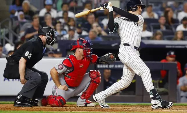 New York Yankees' Cody Bellinger, right, hits a single during the third inning of a baseball game against the Washington Nationals, Monday, Aug. 25, 2025, in New York. (AP Photo/Noah K. Murray)