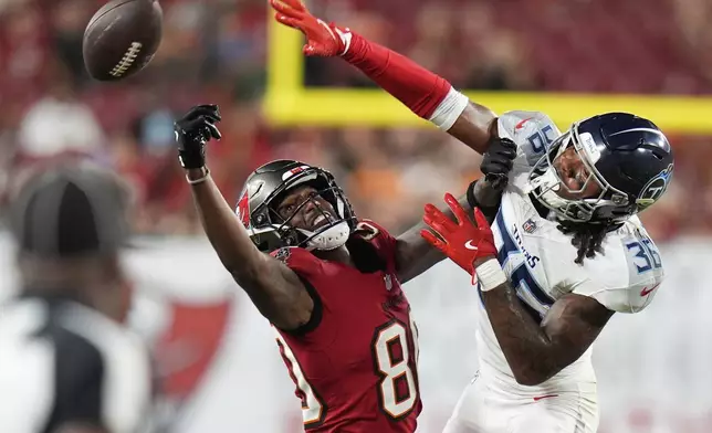 Tennessee Titans cornerback Clarence Lewis breaks up a pass intended for Tampa Bay Buccaneers wide receiver Jaden Smith during the second half of an NFL preseason football game on Saturday, Aug. 9, 2025, in Tampa, Fla. (AP Photo/Chris O'Meara)
