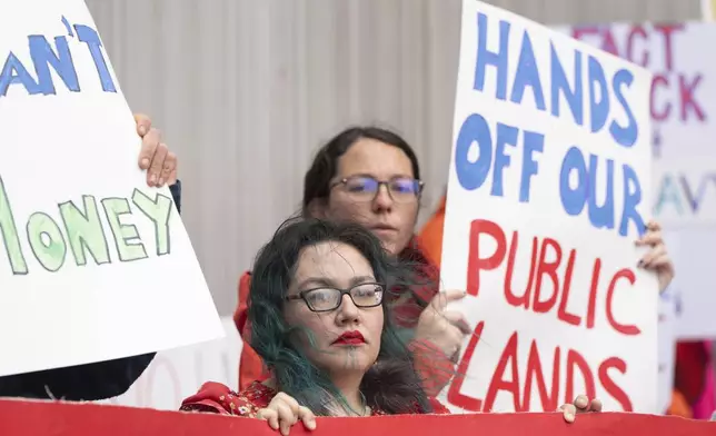 FILE - Demonstrators hold signs during a protest outside the annual Alaska Sustainable Energy Conference on Tuesday, June 3, 2025, in Anchorage, Alaska. (AP Photo/Jenny Kane, File)