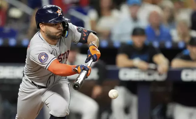 Houston Astros' Jose Altuve bunts for a single, in the fourth inning of a baseball game against the Miami Marlins, Monday, Aug. 4, 2025, in Miami. (AP Photo/Rebecca Blackwell)