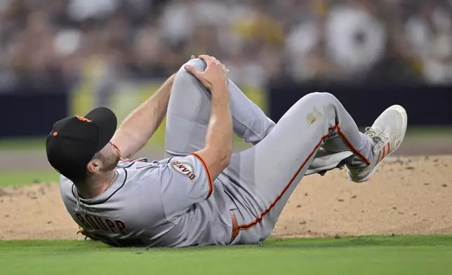 San Francisco Giants starting pitcher Landen Roupp reacts after being hit by a line drive during the third inning of a baseball game against the San Diego Padres Wednesday, Aug. 20, 2025, in San Diego. (AP Photo/Orlando Ramirez)