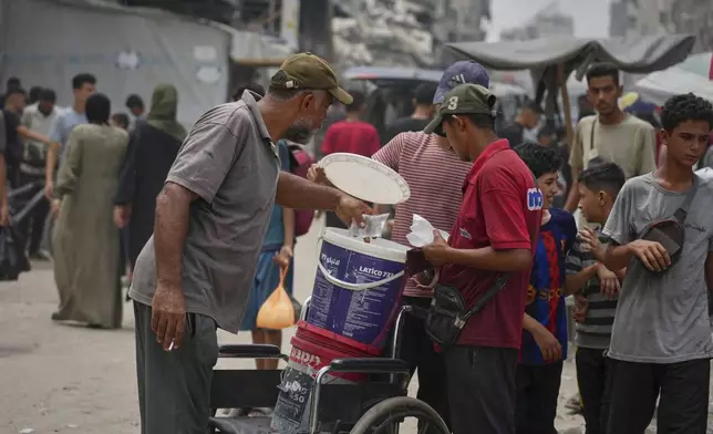 In the summer heat, a man sells plastic bags of water for one shekel each, in Gaza City, Tuesday, Aug. 12, 2025. (AP Photo/Jehad Alshrafi)