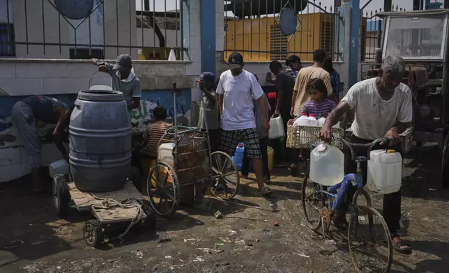 Palestinians collect drinking water at a desalination plant in Deir al-Balah, central Gaza Strip, Wednesday, Aug. 13, 2025. (AP Photo/Abdel Kareem Hana)