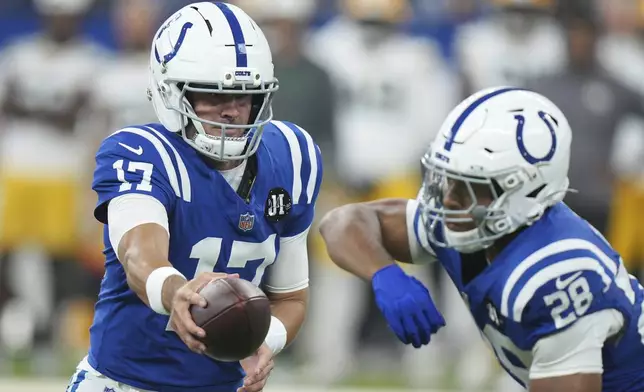 Indianapolis Colts quarterback Daniel Jones (17) hands off to Jonathan Taylor (28) during the first half of a preseason NFL football game against the Green Bay Packers, Saturday, Aug. 16, 2025, in Indianapolis. (AP Photo/AJ Mast)