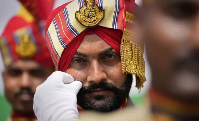 A Sikh paramilitary person adjusts his moustache before taking part in a parade during the country's Independence Day celebrations in Guwahati, India, Friday, Aug. 15, 2025. (AP Photo/Anupam Nath)