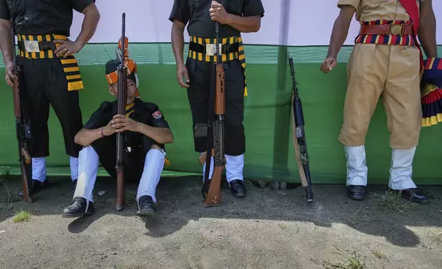 Assam Police personnel rest after a parade during the country's Independence Day celebrations in Guwahati, Friday, Aug. 15, 2025. (AP Photo/Anupam Nath)