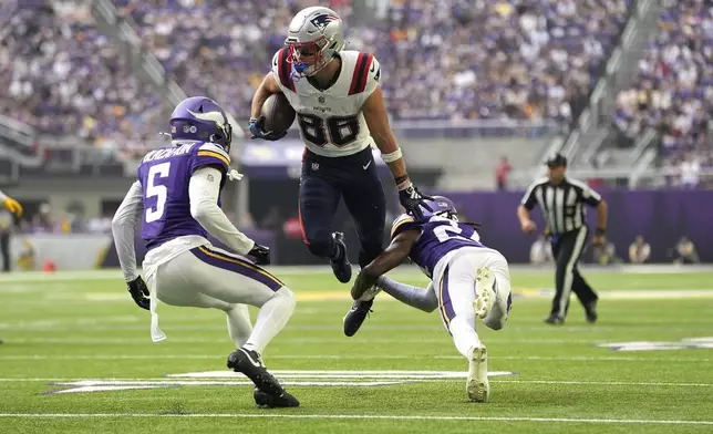 New England Patriots wide receiver Efton Chism III (86) avoids a tackle from Minnesota Vikings safety Jay Ward, right, and cornerback Mekhi Blackmon (5) to score a touchdown during the first half of a preseason NFL football game Saturday, Aug. 16, 2025, in Minneapolis. (AP Photo/Abbie Parr)