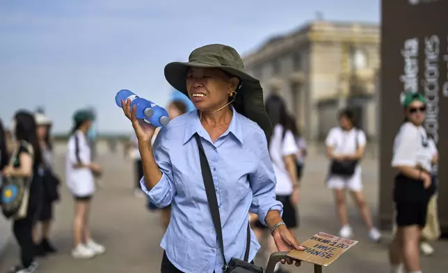 A street vendor sells bottles of water during a heat wave in Madrid, Spain, Tuesday, Aug. 12, 2025. (AP Photo/Manu Fernandez)