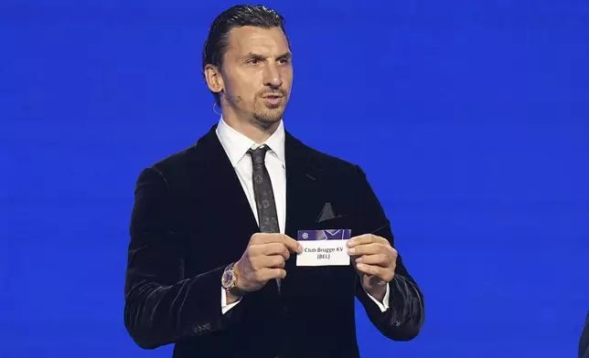 Former soccer star Zlatan Ibrahimovic displays Club Brugge during the Champions League soccer league phase draw in Monaco, Thursday, Aug. 28, 2025. (AP Photo/Laurent Cipriani)