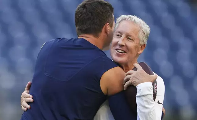 Seattle Seahawks quarterback Drew Lock hugs Las Vegas Raiders head coach Pete Carroll before an NFL preseason football game Thursday, Aug. 7, 2025, in Seattle. (AP Photo/Lindsey Wasson)