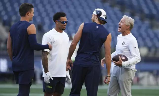 From left, Seattle Seahawks quarterback Drew Lock, wide receiver Jaxon Smith-Njigba and wide receiver Jake Bobo talk with Las Vegas Raiders head coach Pete Carroll, right, before an NFL preseason football game Thursday, Aug. 7, 2025, in Seattle. (AP Photo/Lindsey Wasson)