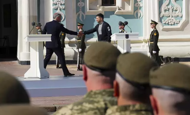 Canada's Prime Minister Mark Carney shakes hands with Ukrainian President Volodymyr Zelenskyy following their speeches, during a ceremony on Independence Day in Sophia Square, in Kyiv, Ukraine, on Sunday, Aug. 24, 2025. (Sean Kilpatrick//The Canadian Press via AP)