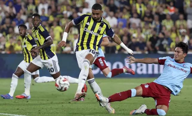 Fenerbahce's Youssef En-Nesyri, center, attempts a shot at goal against Feyenoord's Tsuyoshi Watanabe during a Champions League third qualifying round second leg soccer match between Fenerbahce and Feyenoord at the Ulker stadium, in Istanbul, Turkey, Tuesday, Aug. 12, 2025. (Huseyin Yavuz/Dia Photo via AP)
