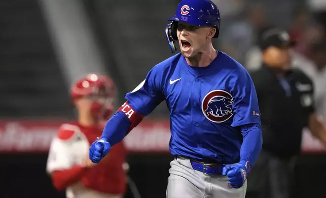 Chicago Cubs' Pete Crow-Armstrong, right, celebrates toward his dugout after hitting a solo home run as Los Angeles Angels catcher Logan O'Hoppe, left, kneels at the plate during the XX inning of a baseball game Friday, Aug. 22, 2025, in Anaheim, Calif. (AP Photo/Mark J. Terrill)