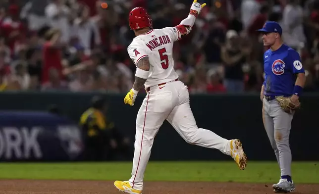 Los Angeles Angels' Yoan Moncada, left, gestures after hitting a solo home run as Chicago Cubs third baseman Matt Shaw stands by during the fifth inning of a baseball game Friday, Aug. 22, 2025, in Anaheim, Calif. (AP Photo/Mark J. Terrill)