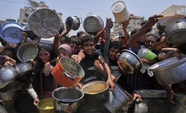 Palestinians struggle to get donated food at a community kitchen in Gaza City, northern Gaza Strip, July 26, 2025. (AP Photo/Abdel Kareem Hana)