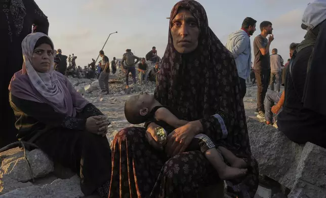 Somoud Wahdan looks at the camera while she and her child wait for trucks of humanitarian aid to arrive in Gaza City, July 25, 2025. (AP Photo/Abdel Kareem Hana)