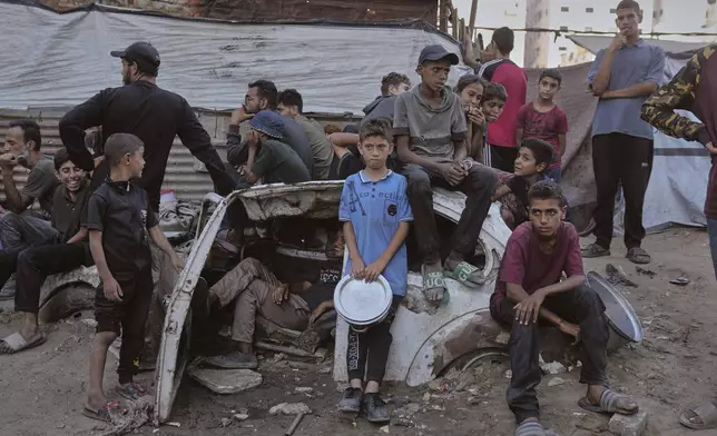 Palestinians wait for donated food at a community kitchen in Gaza City, in the northern Gaza Strip, July 14, 2025. (AP Photo/Jehad Alshrafi)