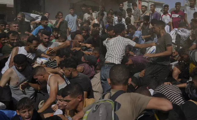 Palestinians struggle to collect humanitarian aid airdropped into Gaza City, northern Gaza Strip, Thursday, Aug. 14, 2025. (AP Photo/Jehad Alshrafi)