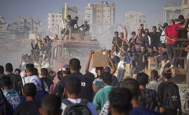 Palestinians ride on a truck loaded with food and humanitarian aid from the World Food Program, after it arrived in the northern Gaza Strip, June 16, 2025. (AP Photo/Jehad Alshrafi)