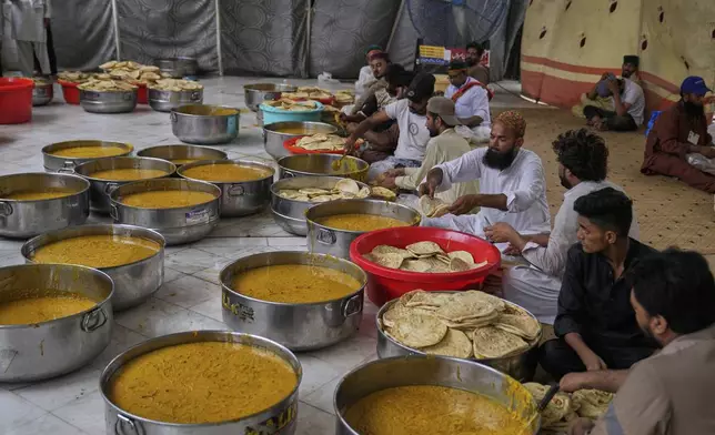 Volunteers pack food for devotees attending celebrations of the three-day annual festival or 'Urs' of famous saint Hazrat Ali Hajveri, popularly known as Data Ganj Bakhsh at his shrine, in Lahore, Pakistan, Friday, Aug. 15, 2025. (AP Photo/K.M. Chaudary)