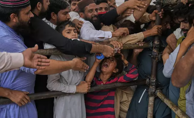 Devotees jostle to get free food as they attending celebrations of the three-day annual festival or 'Urs' of famous saint Hazrat Ali Hajveri, popularly known as Data Ganj Bakhsh at his shrine, in Lahore, Pakistan, Friday, Aug. 15, 2025. (AP Photo/K.M. Chaudary)