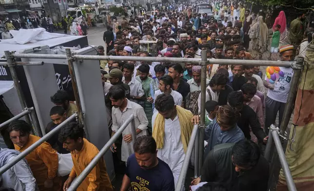 Devotees pass walk through gate at a checkpoint as they arrive to attend the celebrations of the three-day annual festival or 'Urs' of famous saint Hazrat Ali Hajveri, popularly known as Data Ganj Bakhsh at his shrine, in Lahore, Pakistan, Thursday, Aug. 14, 2025. (AP Photo/K.M. Chaudary)