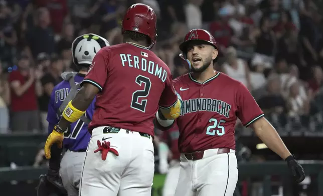 Arizona Diamondbacks' Adrian Del Castillo celebrates with Geraldo Perdomo (2) after hitting a three-run home run against the Colorado Rockies in the first inning of a baseball game, Sunday, Aug 10, 2025, in Phoenix. (AP Photo/Rick Scuteri)