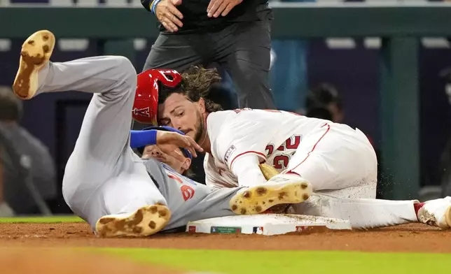 Los Angeles Angels' Bryce Teodosio, right, is tagged out by Los Angeles Dodgers third baseman Alex Freeland as he tries to steal third during the seventh inning of a baseball game Wednesday, Aug. 13, 2025, in Anaheim, Calif. (AP Photo/Mark J. Terrill)
