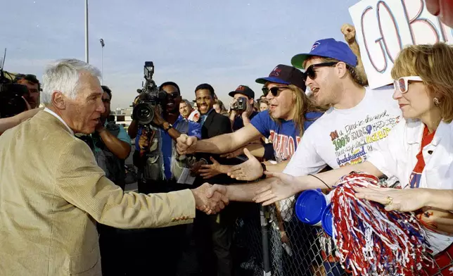 FILE - Buffalo Bills head coach Marv Levy, left, is greeted by fans during the team's arrival for the Super Bowl, Jan. 24, 1993, at Long Beach, Calif. (AP Photo/Doug Pizac, File)