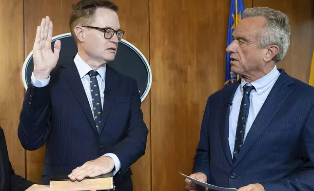 In this photo provided by the Department of Health and Human Secretary, Robert F. Kennedy, Jr., right, conducts the swearing-in ceremony of Jim O'Neill as the Department's Deputy Secretary, June 9, 2025, in Washington. (Amy Rossetti/Department of Health and Human Services via AP)