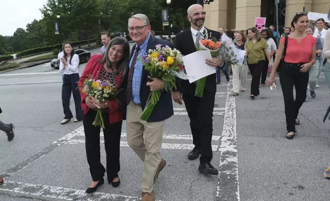 Dr. Debra Houry, left, Dr. Daniel Jernigan and Dr. Demetre Daskalakis gather as workers and supporters rally for departing scientific leaders at the Centers for Disease Control and Prevention outside the CDC headquarters, Thursday, Aug. 28, 2025, in Atlanta. (AP Photo/Ben Gray)