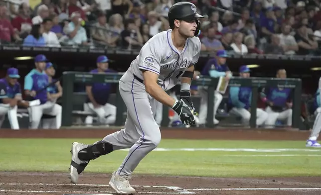 Colorado Rockies' Kyle Karros starts to run after hitting an RBI single on his major league at-bat debut against the Arizona Diamondbacks in the second inning of a baseball game, Friday, Aug. 8, 2025, in Phoenix. (AP Photo/Rick Scuteri)