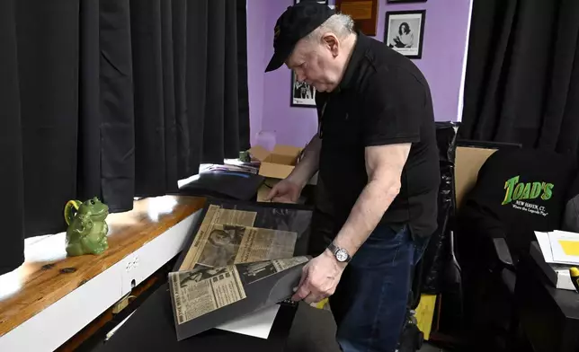 Brian Phelps, owner of Toad's Place, looks over newspaper clippings he has collected about the famous concert venue in New Haven, Conn., on Friday, May 9, 2025. (AP Photo/Jessica Hill)