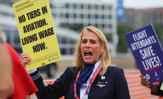 Sara Nelson, the international president of the Association of Flight Attendants-CWA, holds placard during a demonstration at Ronald Reagan Washington National Airport, Monday, August 18, 2025, in Washington. (AP Photo/Rahmat Gul)