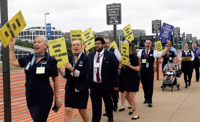 PSA Airlines flight attendants hold placards during a demonstration at Ronald Reagan Washington National Airport, Monday, August 18, 2025, in Washington. (AP Photo/Rahmat Gul)