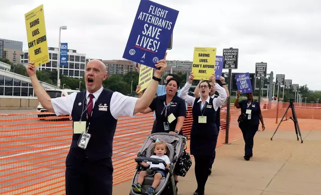 PSA Airlines flight attendants hold placards during a demonstration at Ronald Reagan Washington National Airport, Monday, August 18, 2025, in Washington. (AP Photo/Rahmat Gul)