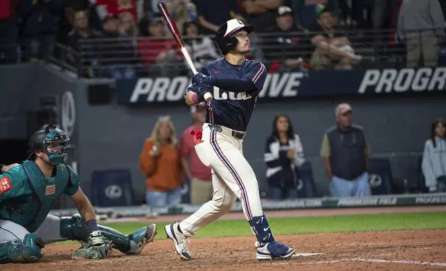 Cleveland Guardians' Steven Kwan, right, watches his winning sacrifice fly off Seattle Mariners' Andres Munoz as Mariners catcher Cal Raleigh, left, looks on during the ninth inning of a baseball game, Friday, Aug. 29, 2025, in Cleveland. (AP Photo/Phil Long)